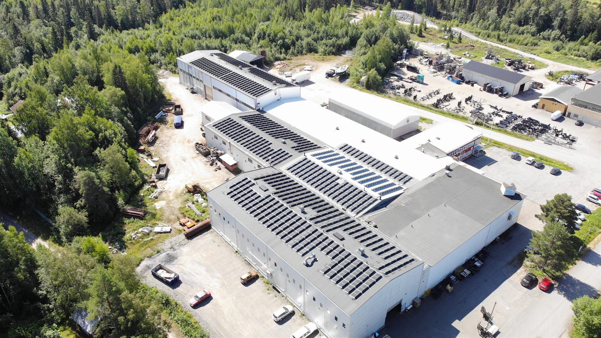 Ilmakuva teollisuuskiinteistöstä, jonka katoilla on aurinkopaneeleja